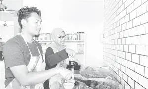  ?? — Gambar Bernama ?? BERANI MENCUBA: Zain ‘Aliuddin membantu Nadwatul memasak rendang arnab ketika ditemui Bernama di rumahnya di Kampung Hulu Teris baru-baru ini.