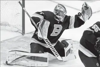  ?? STUART CAHILL / BOSTON HERALD FILE ?? Bruins goaltender Jeremy Swayman makes a glove save against the Islanders at the Garden on April 16.