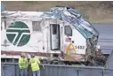  ?? ELAINE THOMPSON/AP ?? Workers examine the engine from the Amtrak train that crashed onto Interstate 5 on Monday in DuPont, Wash.