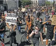  ?? AP PHOTO/MATT DUNHAM ?? People march towards Trafalgar Square in central London on Sunday to protest against the recent killing of George Floyd by police officers in Minneapoli­s that has led to protests across the U.S.