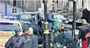  ??  ?? Emergency services surround the car used in the attack after it crashed into railings outside the Palace of Westminste­r