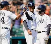  ?? Paul Sancya / Associated Press ?? Detroit's Eric Haase, right, celebrates his three-run inside-the-park home run with Miguel Cabrera, left, and Jonathan Schoop in the fourth inning on Saturday.