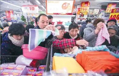  ?? XU KANGPING / FOR CHINA DAILY ?? Shoppers rush to buy goods for daily use on sale at a supermarke­t in Hangzhou, Zhejiang province, on Tuesday, or the Double 12 shopping gala.