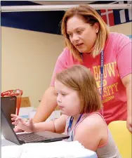  ?? Janelle Jessen/Herald-Leader ?? Abby Gatlin received guidance from Adria Trombley, assistant professor of teacher education, as she practiced writing poetry on Thursday morning. Elementary-schoolaged children spent the week learning about experienci­ng the world through poetry as part...