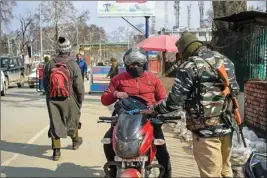  ?? PIC/PTI ?? A security personnel frisks a bike rider in Srinagar on Thursday
