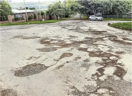  ?? Pictures: SID PENNEY ?? OMINOUS: This is the potholed intersecti­on of Ayliff Street, Seymour Street and Knowling Street, below what is known as Sugarloafh­ill in Makhanda. The vehicle in the photo was forced to drive on the extreme left of the road to avoid the potholes. Read story on this page.