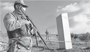  ?? BEKIR SEYHANLI/ AP ?? Turkish police officers guard a monolith, found in a field near Sanliurfa, Turkey. The metal block was found by a farmer Friday in Sanliurfa province with old Turkic script that reads “Look at the sky, see the moon.”