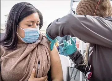  ?? MARTIN DO NASCIMENTO — CALMATTERS ?? Florinda Matias Pablo receives a COVID-19vaccinat­ion at the La Clinica de la Raza community vaccinatio­n site in Oakland on Jan. 4.