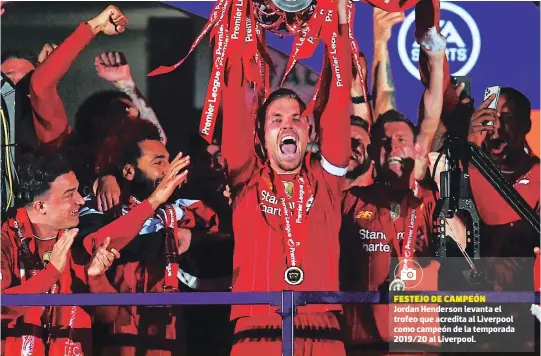 ??  ?? festejo de campeón Jordan Henderson levanta el trofeo que acredita al Liverpool como campeón de la temporada 2019/20 al Liverpool.