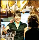  ??  ?? CUT ABOVE: Hanging hams and a glass of wine at a San Sebastian bar