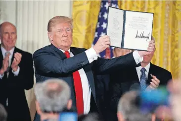  ?? [AP PHOTO] ?? President Donald Trump shows off a “Space Policy Directive” after signing it during a meeting of the National Space Council in the East Room of the White House on Monday in Washington.