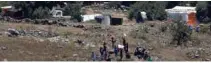  ?? — REUTERS/Ronen Zvulun ?? TRAPPED: People wave white cloths next to the refugee tents erected near the border fence between Israel and Syria from its Syrian side as it is seen from the Israeli-occupied Golan Heights near the Israeli Syrian border July 17, 2018.