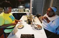  ?? Melissa Phillip / Staff photograph­er ?? G'Nai Blakemore, left, shares dinner in her apartment with her aunt Vicki Brown on Thursday in Houston.