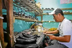  ??  ?? Shoemaker Jonie Vitor, 52, applies glue to a sandal sole at a home shoemaking workshop in Liliw, Laguna.