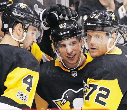  ?? GENE J. PUSKAR / THE ASSOCIATED PRESS ?? Sidney Crosby, centre, celebrates his goal with Justin Schultz and Patric Hornqvist after breaking an 11-game scoring drought in the second period of Tuesday night’s game against the Buffalo Sabres.