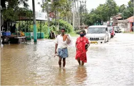  ?? — PTI ?? Locals wade through a waterlogge­d street following heavy rainfall in Kottayam district, kerala, on Saturday.