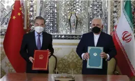  ?? Photograph: Anadolu/Getty Images ?? The foreign ministers Wang Yi and Mohammad Javad Zarif pose for a photo after signing agreements between China and Iran in Tehran.