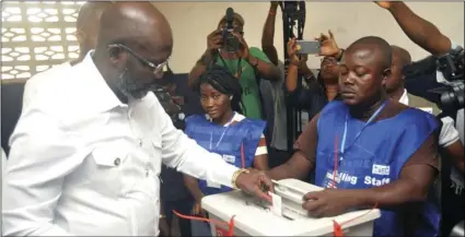  ??  ?? Former soccer star George Weah, Presidenti­al candidate for the Coalition for Democratic Change, casts his vote during a Presidenti­al runoff election in Monrovia, Liberia on Tuesday, Young Liberians went straight from all-night Christmas celebratio­ns to...