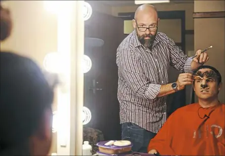  ?? Jessie Wardarski/Post-Gazette ?? Wig master and makeup artist Jeff Knaggs, left, applies the custom-made prosthetic nose and face piece during the halfhour process of turning actor James Snyder into the Beast for Pittsburgh CLO’s “Disney’s Beauty and the Beast.”