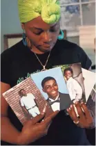  ?? JOE RONDONE/THE COMMERCIAL APPEAL mother of Brandon Webber who was shot by members of the United States Marshals Service ?? Jaleta Clark, mother of Brandon Webber, who was shot and killed by U.S. Marshals in June of 2019, stands in her home surrounded by photos of her son on Monday.