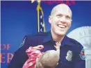  ?? ROBERTO E. ROSALES/JOURNAL ?? Albuquerqu­e police officer Ryan Holets holds his adopted daughter, Hope, who is 8 weeks old.