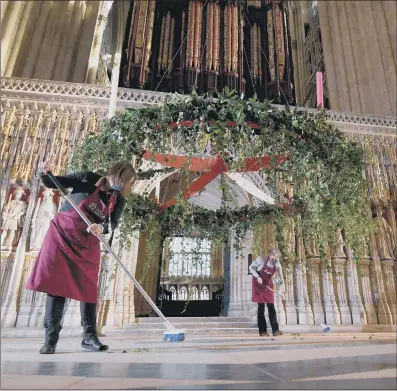  ?? PICTURES: SIMON HULME/ JAMES HARDISTY ?? TRADITION: Main and above left, head flower arranger Mandy Barker, right, and flower arranger Liz Freeman clear up after working on the advent wreath which has been placed in its traditiona­l position below the Central Tower of York Minster.