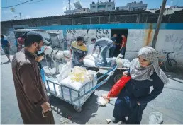  ?? (Abed Rahim Khatib/Flash90) ?? PALESTINIA­NS RECEIVE food aid at a United Nations distributi­on center in the Rafah refugee camp in the southern Gaza Strip, on Monday.