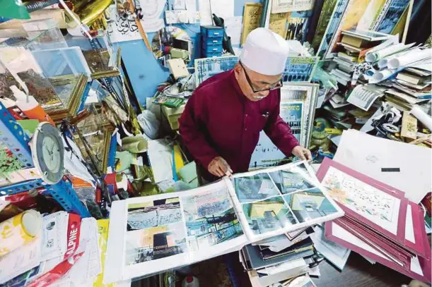  ??  ?? AHMAD melihat gambar lama Makkah yang disimpan di dalam kedainya di bangunan Peruda.