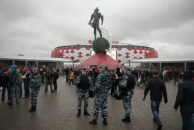  ?? PHOTO/PAVEL GOLOVKIN ?? In this photo taken on Wednesday, April 18 police officers guard before a Russian Premier League Championsh­ip soccer match between Spartak Moscow and Tosno, with the World Cup Spartak stadium in the background, in Moscow, Russia. AP