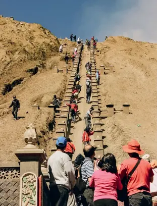  ??  ?? Tourists hike to Gunung Bromo in Bromo Tengger Semeru National Park. Above: A miner carries giant blocks of solid sulphur from the floor of the Kawah Ijen volcano to the valley.