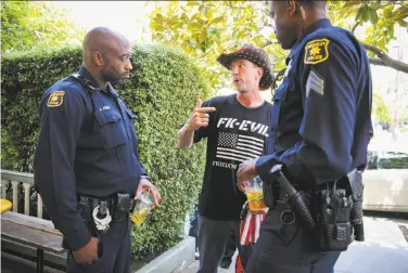  ?? Photos by Gabrielle Lurie / The Chronicle ?? At Coffee With a Cop, David Tomes talks to Berkeley police Officers Jumaane Jones and Spencer Fomby.