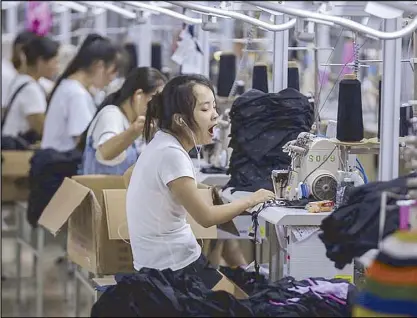  ?? AP ?? Photo shows a woman yawning at a factory making swimsuits in Jinjiang City in Southeast China’s Fujian province. China’s exports accelerate­d in July showing little impact from a US tariff hike, while sales to the US rose 13.3 percent over a year earlier. –