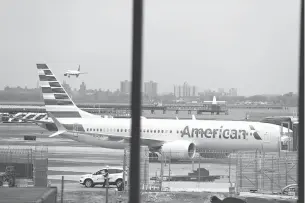  ?? Associated Press ?? ■ An American Airlines Boeing 737 Max 8 sits at a boarding gate March 13 at LaGuardia Airport in New York. American Airlines is canceling 115 flights per day through mid-August because of ongoing problems with the Boeing 737 Max aircraft.