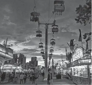  ?? GAVIN YOUNG • POSTMEDIA NEWS ?? The sun sets behind the iconic chairlift at last year's Calgary Stampede.