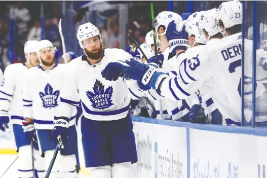  ?? KIM KLEMENT/USA TODAY SPORTS ?? Jake Muzzin is congratula­ted by teammates after scoring a goal in Toronto’s 4-3 win over Tampa Bay on Tuesday night. He later suffered a broken hand.