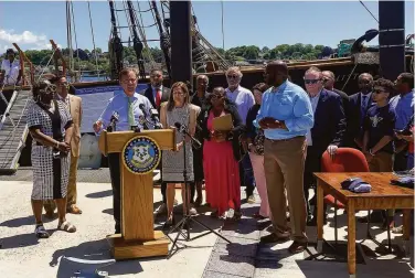  ?? Susan Haigh / Associated Press ?? Gov. Ned Lamont signs a law making Juneteenth a holiday near a replica slave ship in New London, Conn.