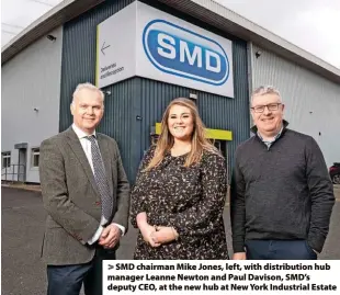  ?? > SMD chairman Mike Jones, left, with distributi­on hub manager Leanne Newton and Paul Davison, SMD’s deputy CEO, at the new hub at New York Industrial Estate ??