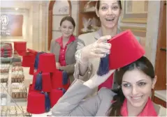  ?? — Reuters file ?? An employee holds a box shaped like a tarbush (fez) on her head that contains dates for special gifts during the month of Ramadhan at a Ghraoui chocolate shop in Damascus.