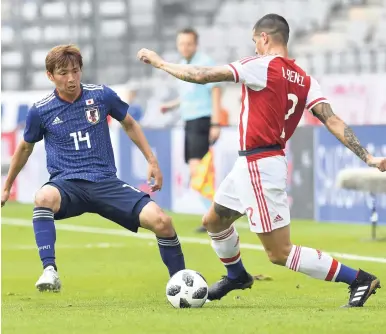  ?? AP ?? Japan’s Takashi Inui (left) and Paraguay’s Alan Benitez challenge for the ball during the friendly match between Japan and Paraguay in the Tivoli Stadium in Innsbruck, Austria yesterday. Japan won 4-2.