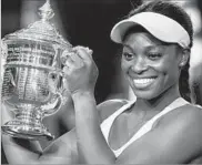  ?? ADAM HUNGER/AP ?? American Sloane Stephens holds up her championsh­ip trophy after beating Madison Keys in the U.S. Open final.