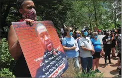  ?? Ernest A. Brown photo ?? Kelly Crim, of Cranston, holds a large poster during the George Floyd Rally in Burnside Park Saturday. After thousands had gathered there and listened to speakers, the protesters headed to the south lawn of the Statehouse, where the rally continued.