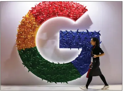  ?? (AP) ?? A woman passes the logo for Google at the China Internatio­nal Import Expo in Shanghai in this file photo.