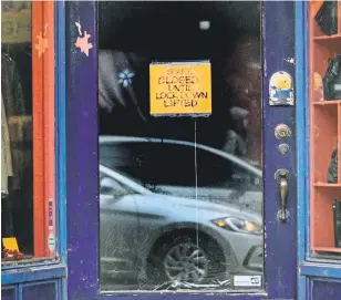  ?? ANDREW FRANCIS WALLACE TORONTO STAR FILE PHOTO ?? A sign notifies customers of the lockdown at a second-hand store in Toronto. The Canadian Federation of Independen­t Business wants the government to let small businesses open up.