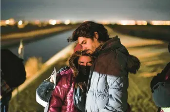  ?? GREGORY BULL/AP ?? A couple from Cuba wait to be processed to seek asylum after crossing the border Jan. 6 into the United States, near Yuma, Arizona. An undergroun­d market has emerged for migrants seeking U.S. sponsors.