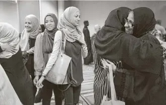  ?? Marie D. De Jesús / Houston Chronicle ?? From left, Camila Almakdah, 18, Aisha Parada, 17, and Kamle Almakdah, 18, wait for their turn to embrace Delmi Realegeño, right, who had just given her testimony of faith at Centro Islamico.