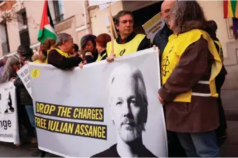  ?? — AFP photo ?? Protestors hold a banner during a rally in support of Assange, in front of the US embassy in Madrid.