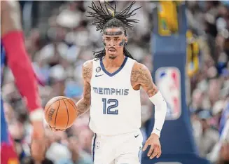  ?? David Zalubowski/Associated Press ?? Memphis Grizzlies guard Ja Morant brings the ball up against the Nuggets during the second half on Friday. He is planning to “take some time away to get help.”