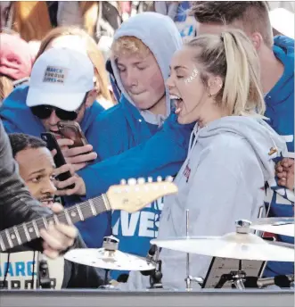  ?? CHIP SOMODEVILL­A GETTY IMAGES ?? Miley Cyrus — another narcissist­ic celebrity — poses for selfies with students last Saturday after performing during the March for Our Lives rally in Washington, DC.