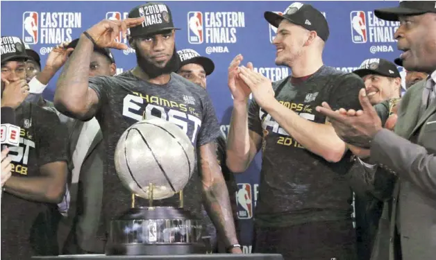  ?? FOTO AP | DISEÑO JULIO ANÍBAL RAMÍREZ ?? LeBron James hace un saludo durante la ceremonia de entrega de la cual, la está junto a él, mientars es aplaudido por varios de sus compañeros luego de que los Cavaliers vencieran a los Celtics