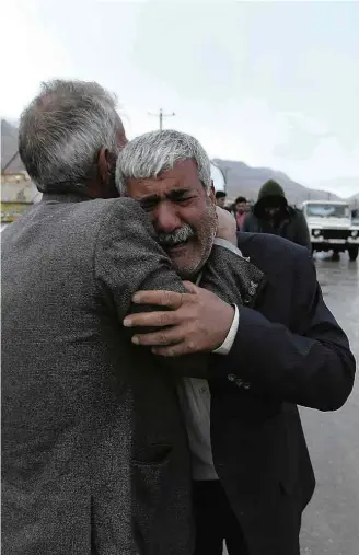  ?? Ali Khodaei/Associated Press ?? Familiar de passageiro do voo EP3704, que caiu no monte Dena, é consolado em Bideh